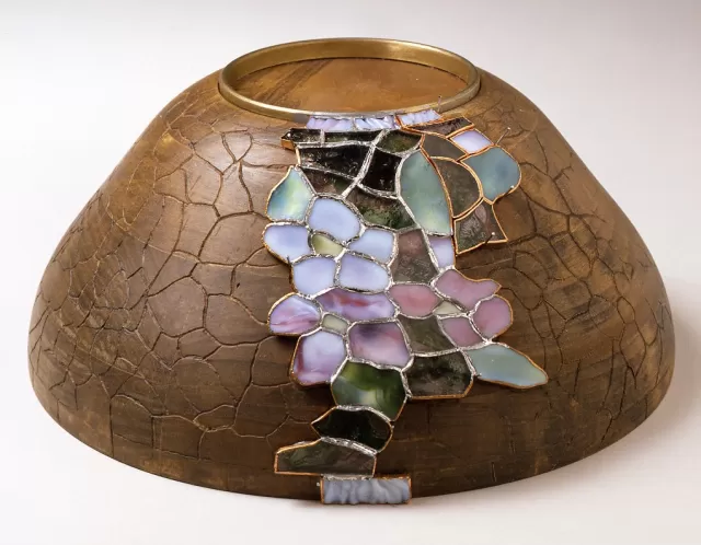Pieces of glass were selected, cut, wrapped in copper foil, and soldered together onto a wooden mold.